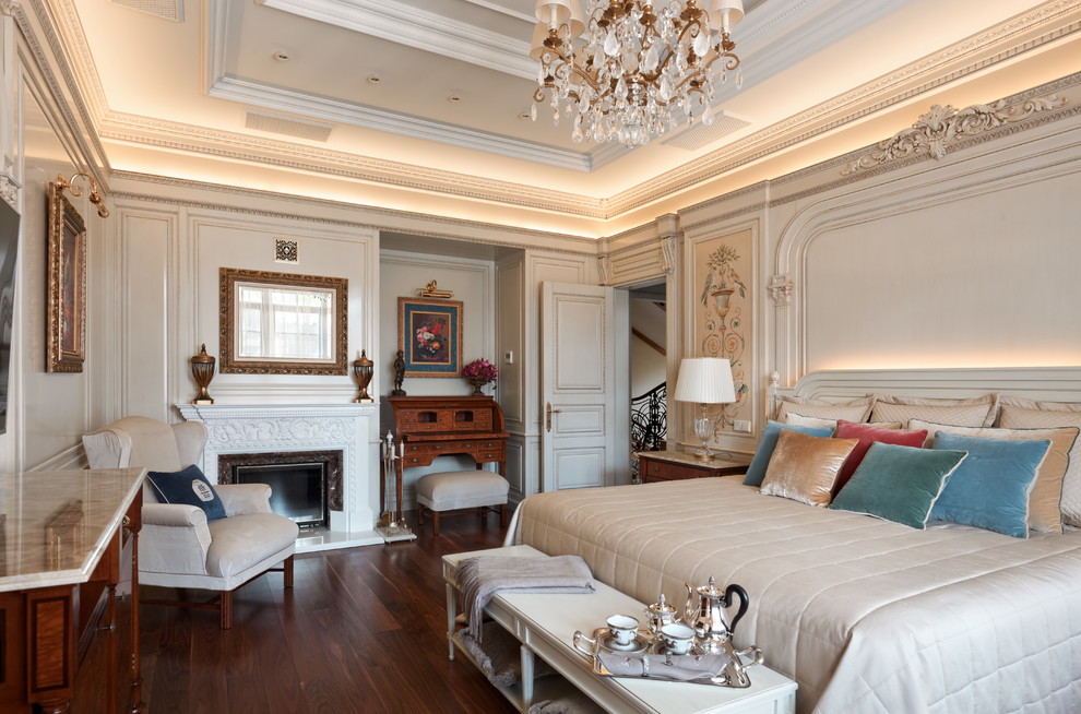 Идея дизайна: хозяйская спальня в классическом стиле с белыми стенами, темным паркетным полом, стандартным камином и коричневым полом