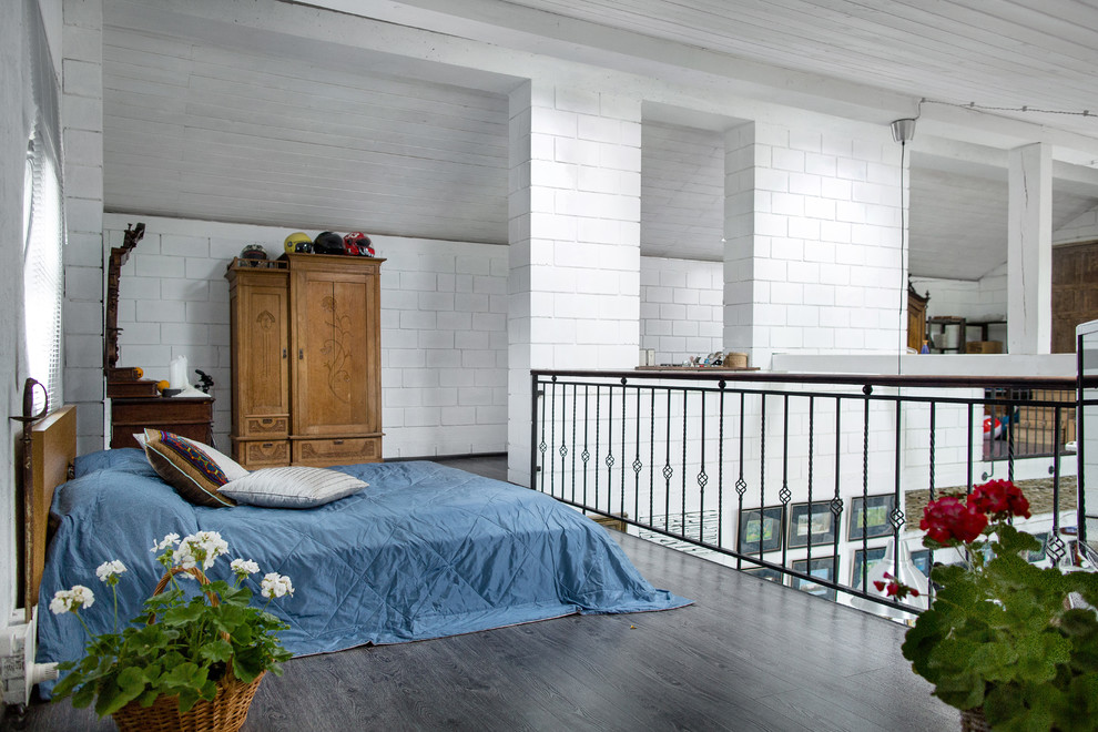 Inspiration pour une chambre mansardée ou avec mezzanine bohème avec un mur blanc et parquet foncé.
