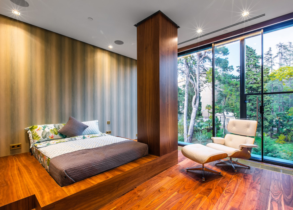 Modernes Schlafzimmer mit grüner Wandfarbe, dunklem Holzboden und braunem Boden in Sonstige