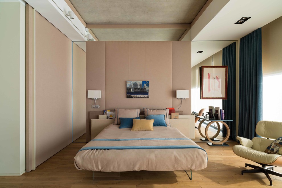Diseño de dormitorio contemporáneo sin chimenea con paredes rosas y suelo de madera clara