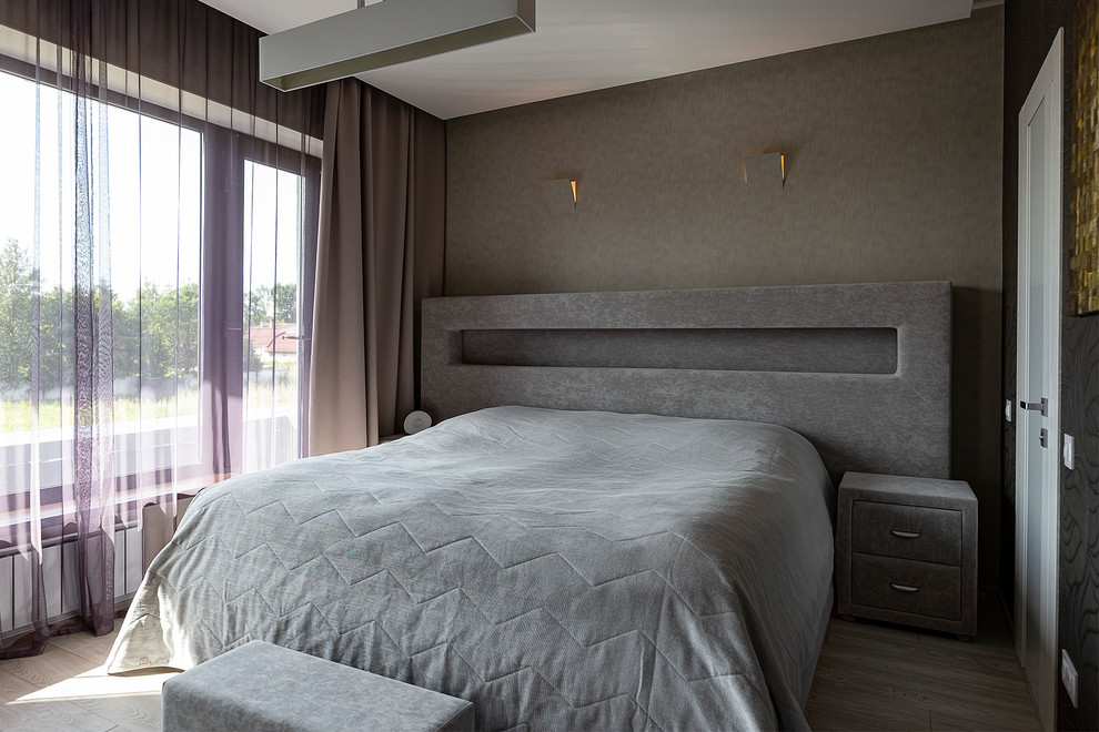 Diseño de dormitorio principal contemporáneo de tamaño medio con paredes marrones, suelo laminado y suelo gris