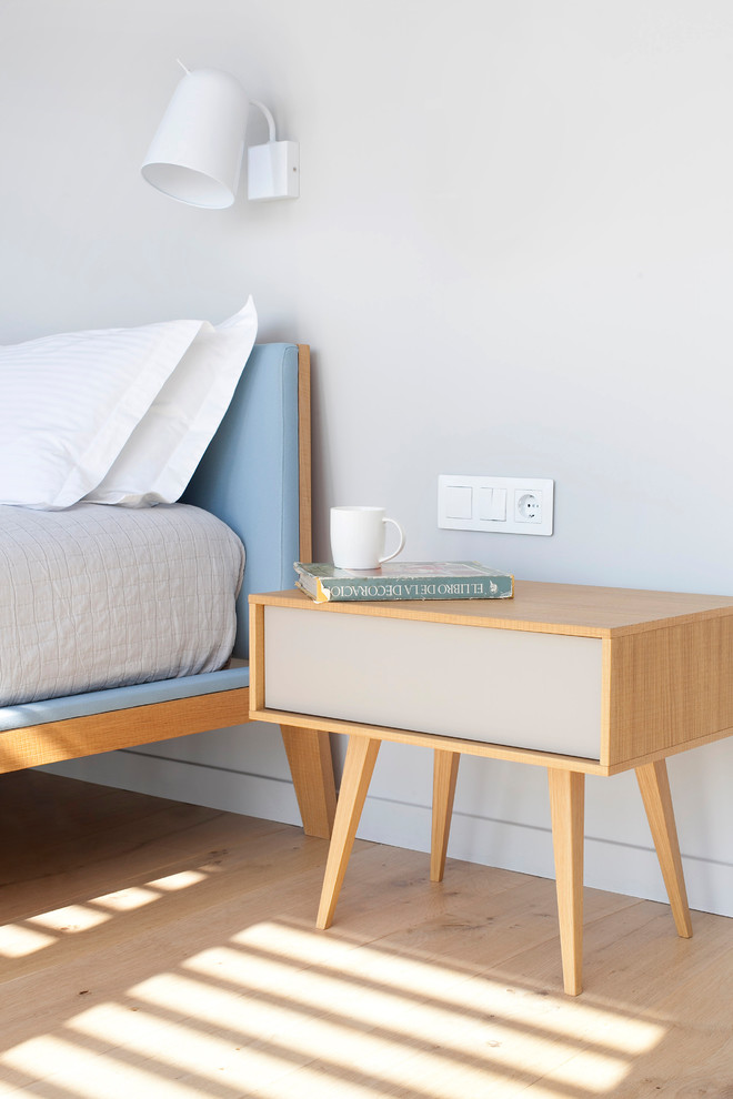Foto de dormitorio principal contemporáneo de tamaño medio sin chimenea con paredes grises y suelo de madera clara