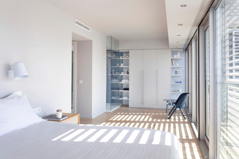 Imagen de dormitorio principal contemporáneo de tamaño medio sin chimenea con paredes grises y suelo de madera clara