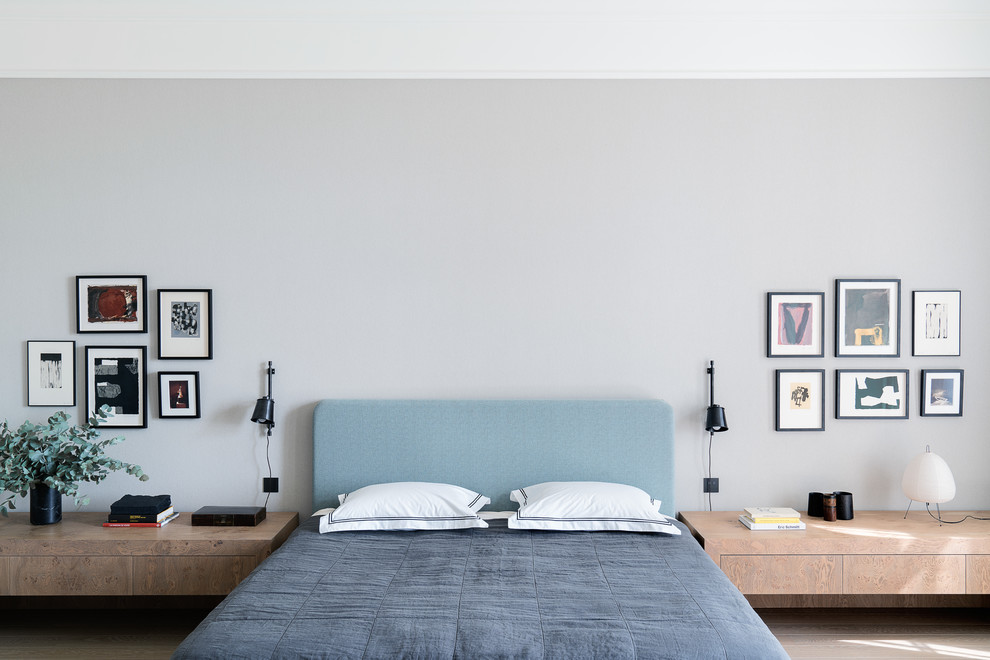На фото: хозяйская спальня в скандинавском стиле с серыми стенами, светлым паркетным полом и бежевым полом