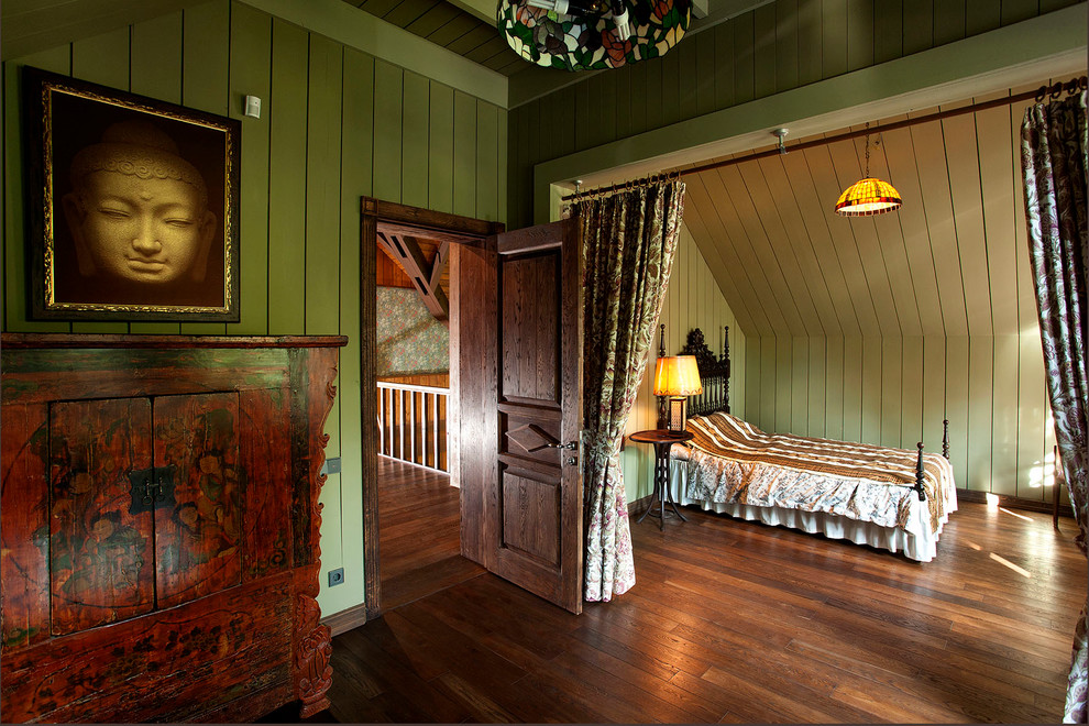 На фото: хозяйская спальня среднего размера на мансарде в стиле фьюжн с зелеными стенами и паркетным полом среднего тона с