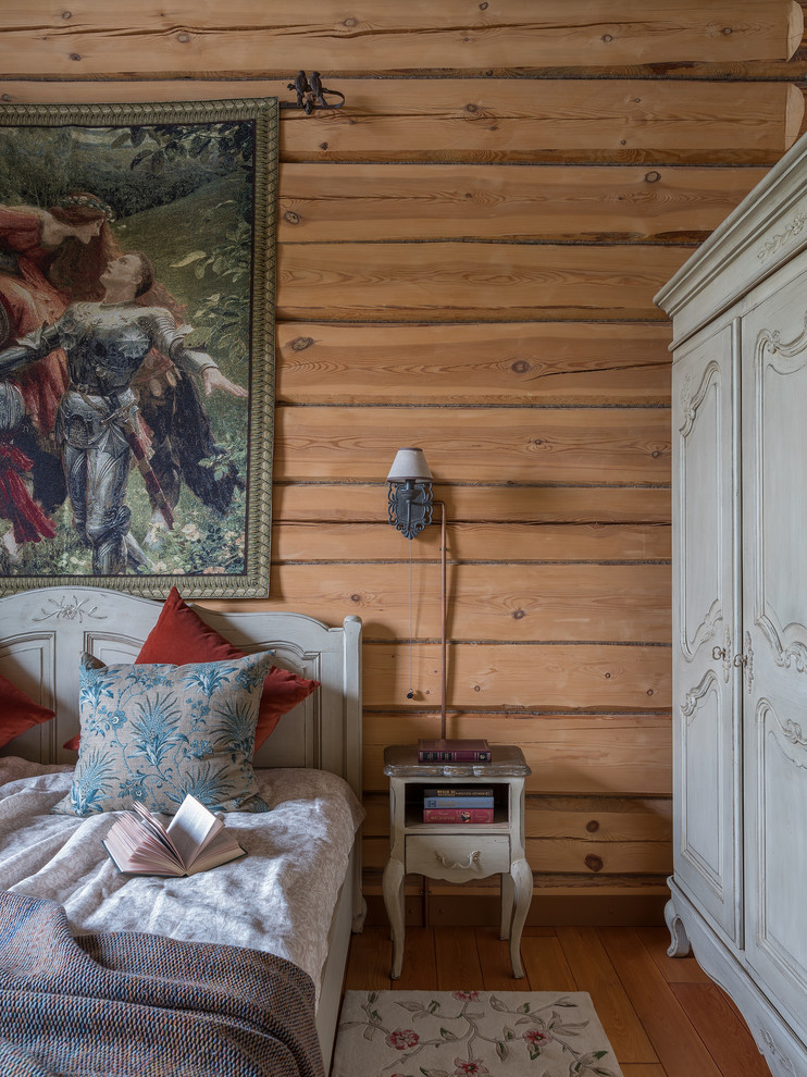 На фото: хозяйская спальня среднего размера в стиле рустика с деревянным полом и коричневым полом с