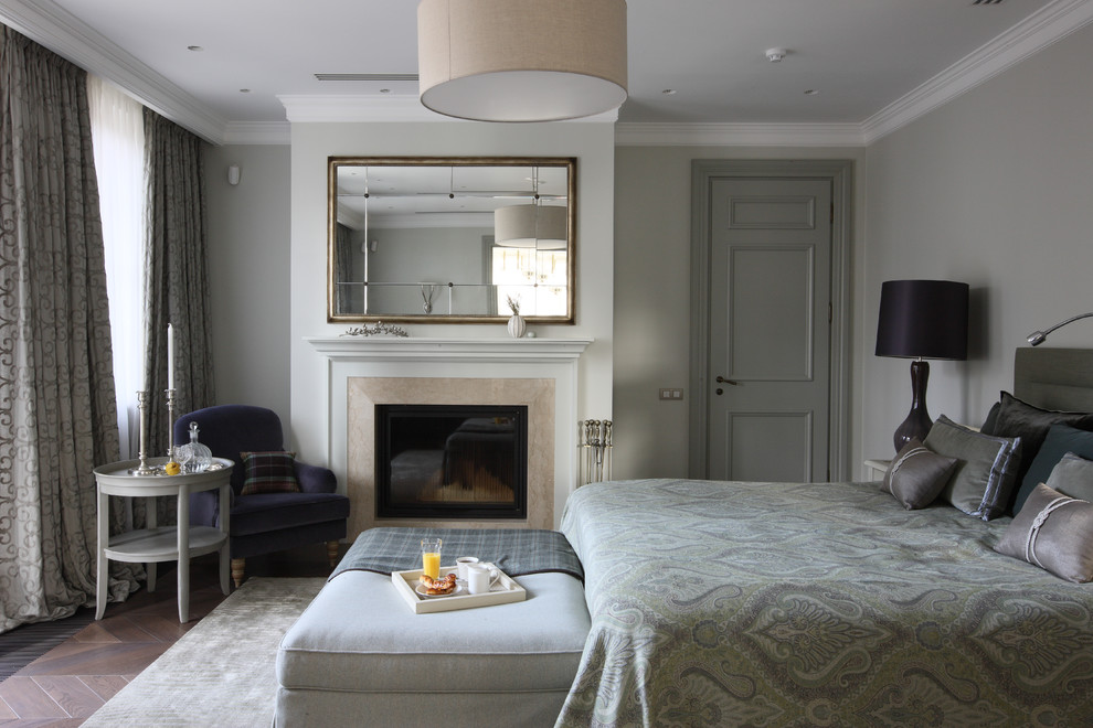 Источник вдохновения для домашнего уюта: большая хозяйская спальня в стиле неоклассика (современная классика) с серыми стенами, паркетным полом среднего тона, стандартным камином и фасадом камина из камня