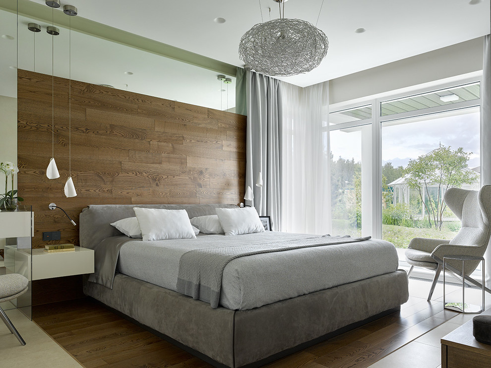 Стильный дизайн: хозяйская спальня: освещение в современном стиле с коричневым полом, коричневыми стенами и паркетным полом среднего тона - последний тренд