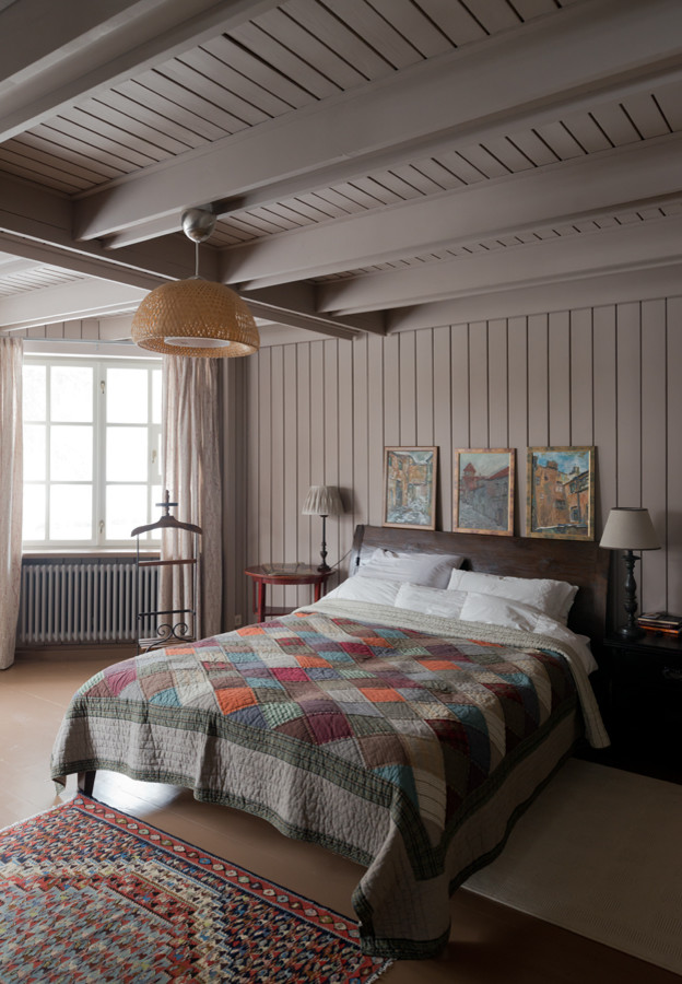Ispirazione per una grande camera matrimoniale country con pareti beige e pavimento in legno verniciato