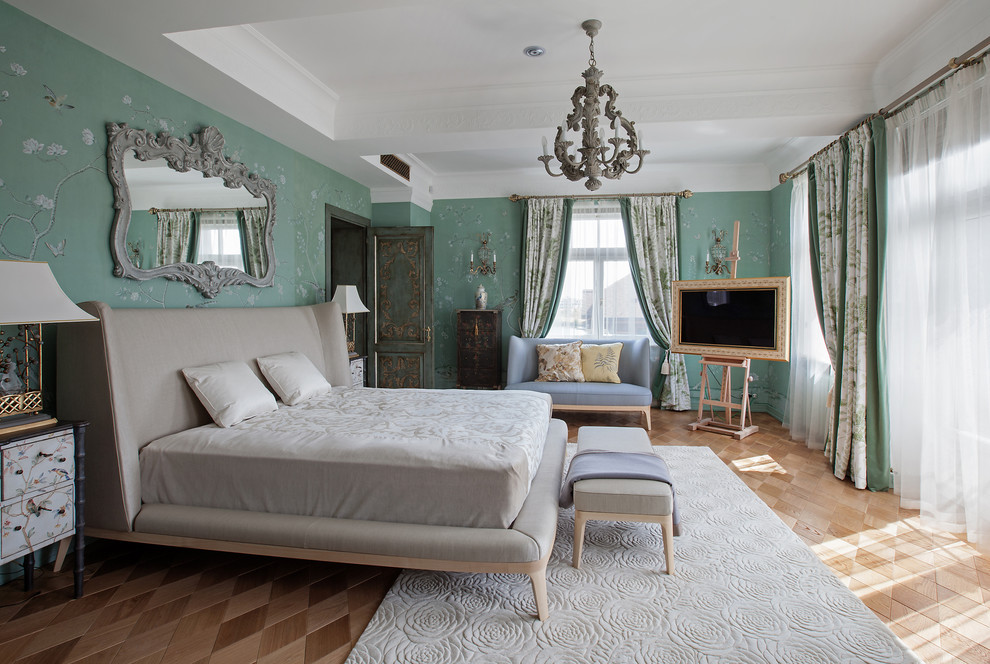 Imagen de dormitorio principal y televisión tradicional grande con paredes verdes y suelo de madera en tonos medios
