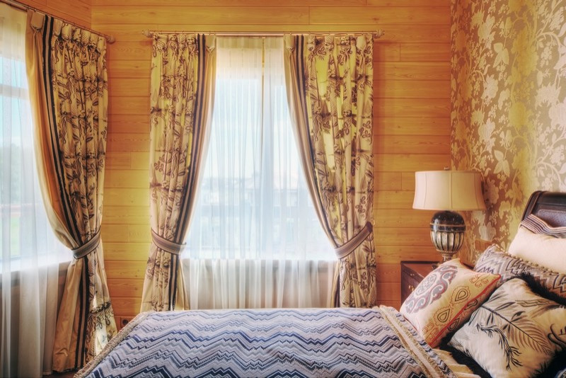 Diseño de dormitorio principal tradicional renovado grande con paredes beige, suelo de madera en tonos medios y suelo rojo