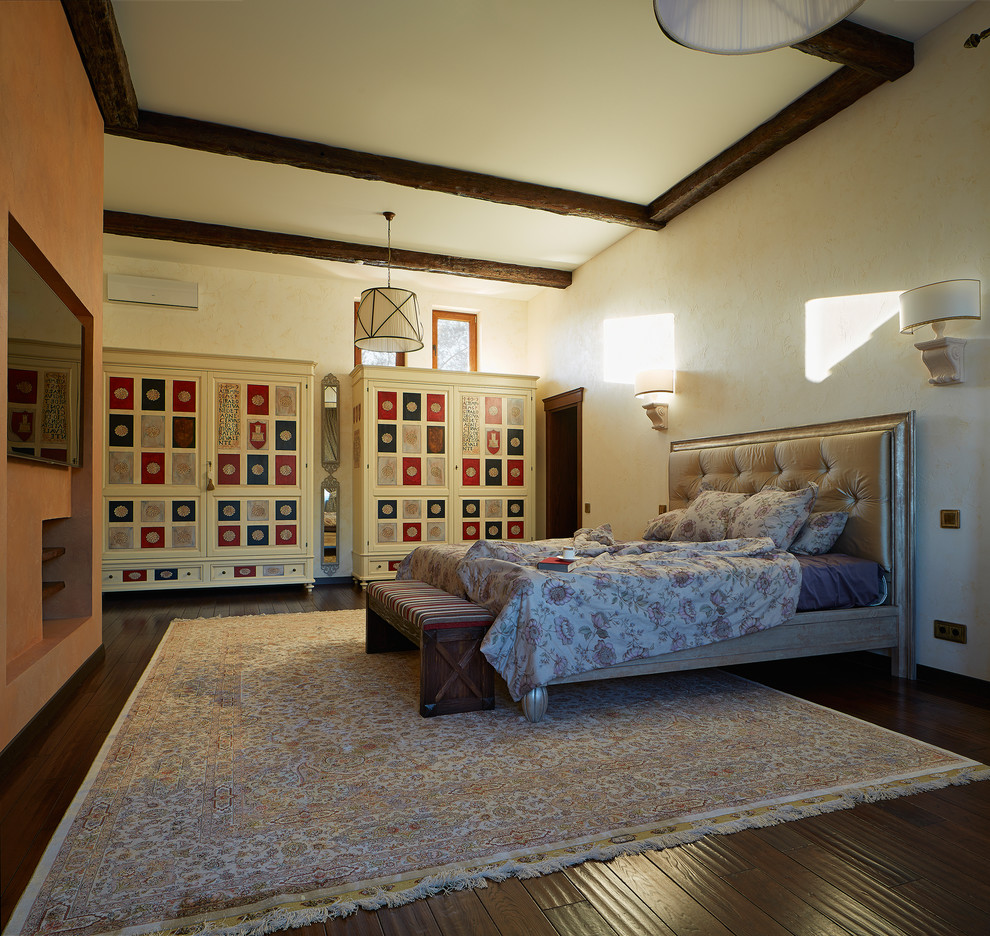 На фото: хозяйская спальня среднего размера в стиле фьюжн с белыми стенами и темным паркетным полом без камина с