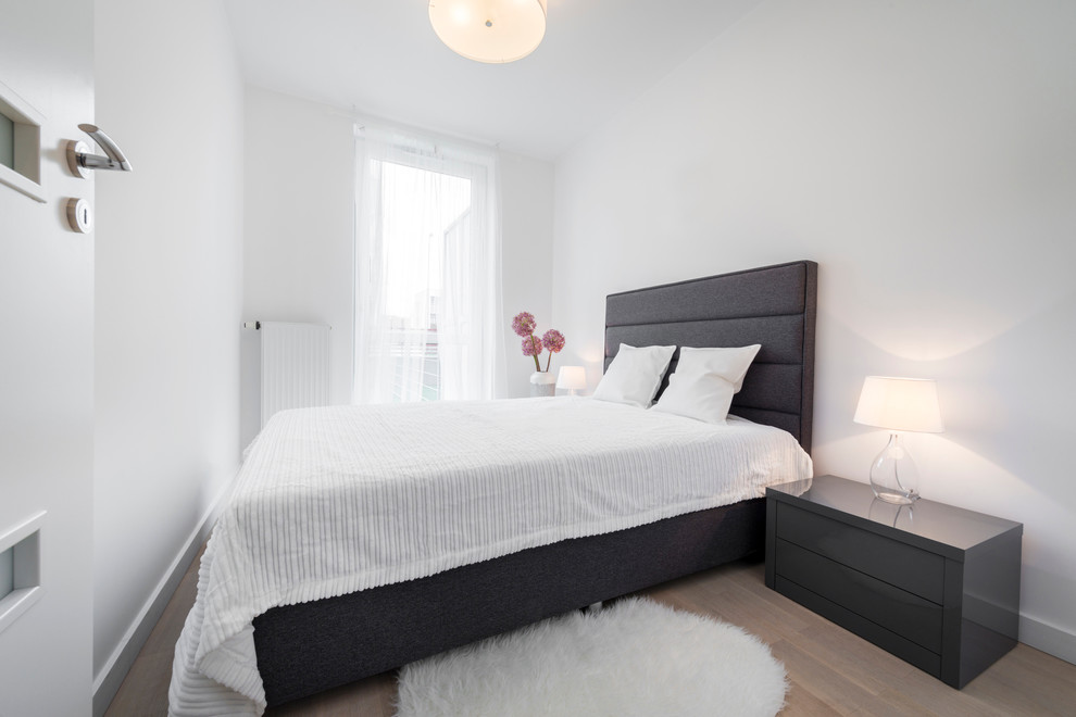 Kleines Skandinavisches Hauptschlafzimmer ohne Kamin mit weißer Wandfarbe und hellem Holzboden in Moskau