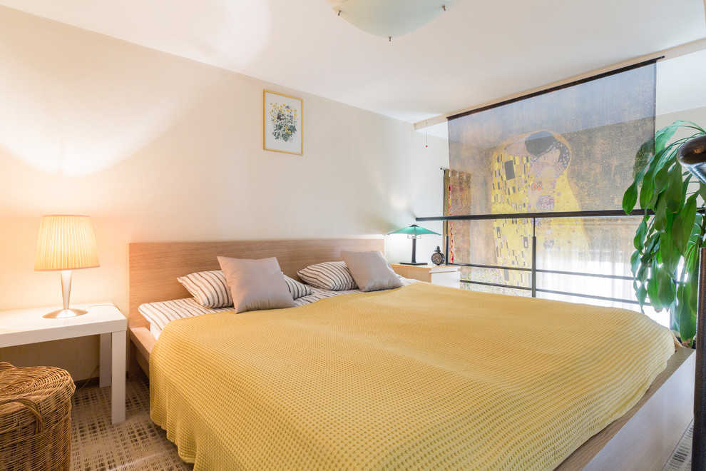 Immagine di una camera da letto stile loft contemporanea con pareti beige, moquette e pavimento multicolore