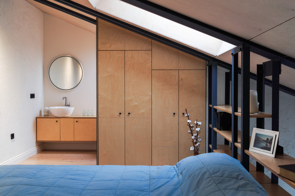 Ispirazione per una camera da letto design con pareti grigie, pavimento in legno massello medio e pavimento marrone