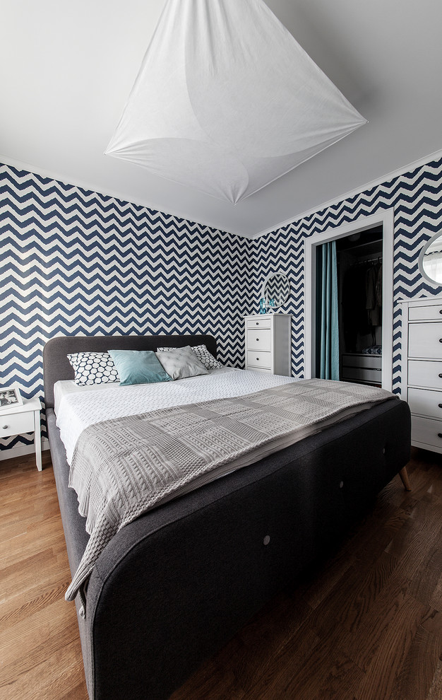 Ispirazione per una piccola camera matrimoniale design con pareti multicolore, pavimento in legno massello medio, pavimento marrone e carta da parati