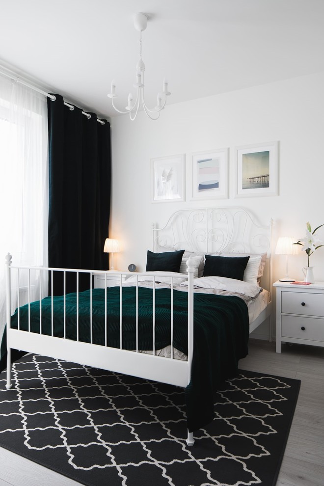 Ejemplo de dormitorio principal nórdico de tamaño medio con paredes blancas, suelo laminado y suelo gris