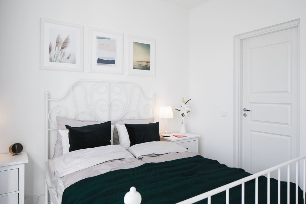Пример оригинального дизайна: хозяйская спальня среднего размера в скандинавском стиле с белыми стенами, полом из ламината и серым полом