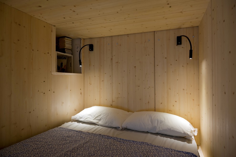 Esempio di una piccola camera da letto stile loft contemporanea con pareti bianche e pavimento in laminato