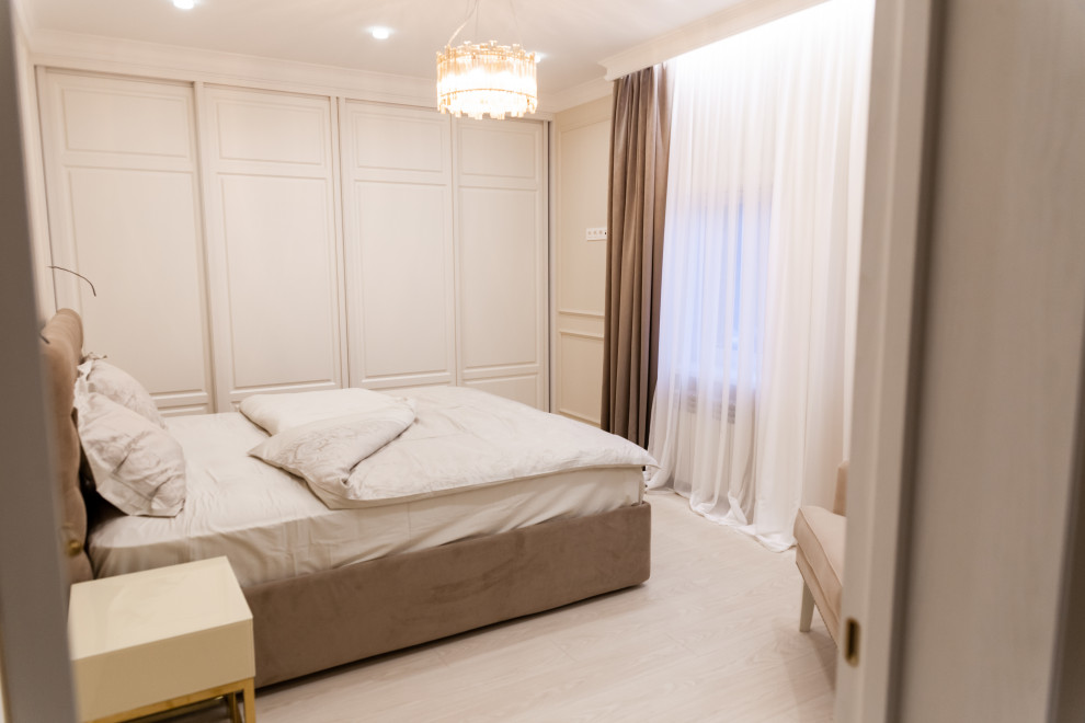 Ispirazione per una camera matrimoniale tradizionale di medie dimensioni con pareti beige, pavimento in laminato e pavimento beige
