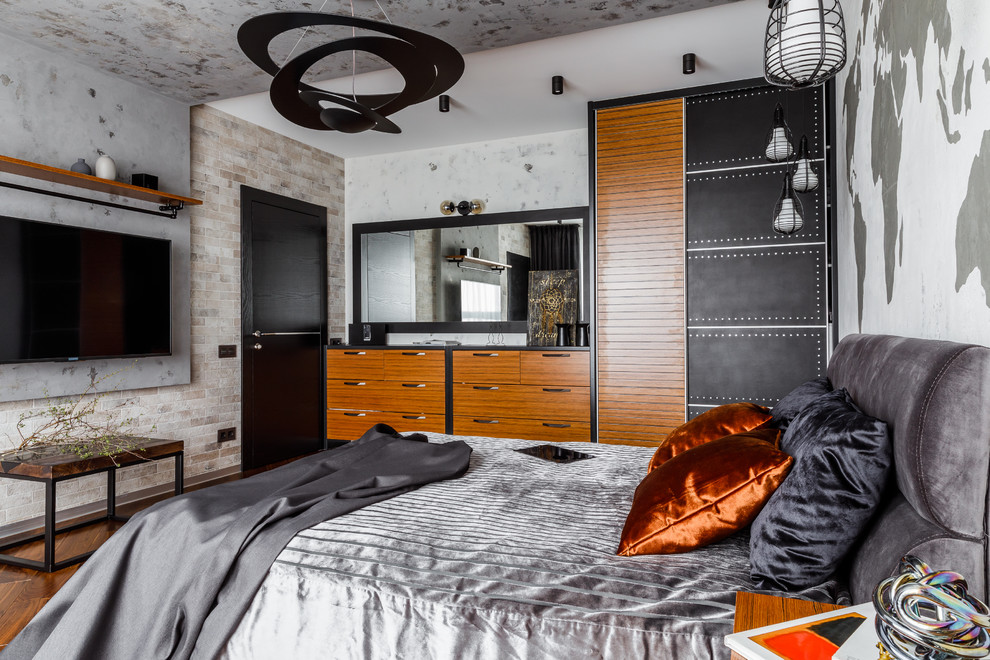 Ejemplo de dormitorio principal urbano de tamaño medio con paredes grises, suelo de madera en tonos medios y suelo marrón