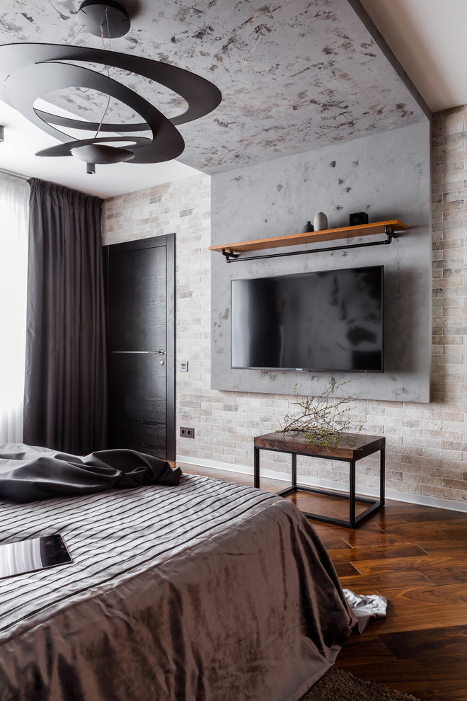 Imagen de dormitorio principal industrial de tamaño medio con paredes grises, suelo de madera en tonos medios y suelo marrón