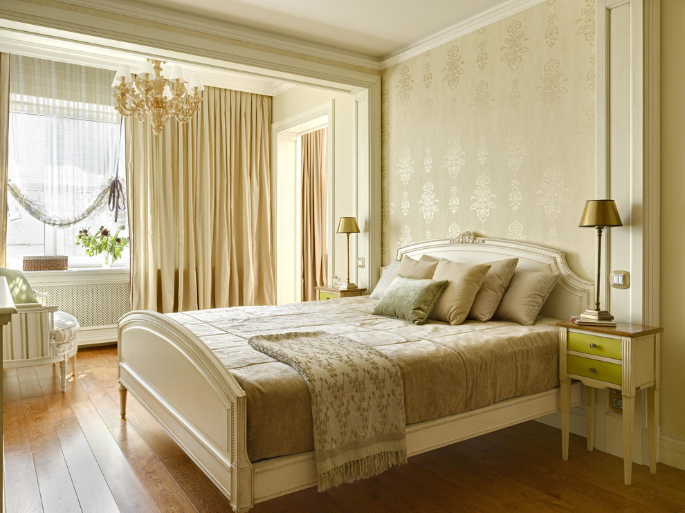 Modelo de dormitorio principal tradicional de tamaño medio con paredes beige y suelo de madera en tonos medios
