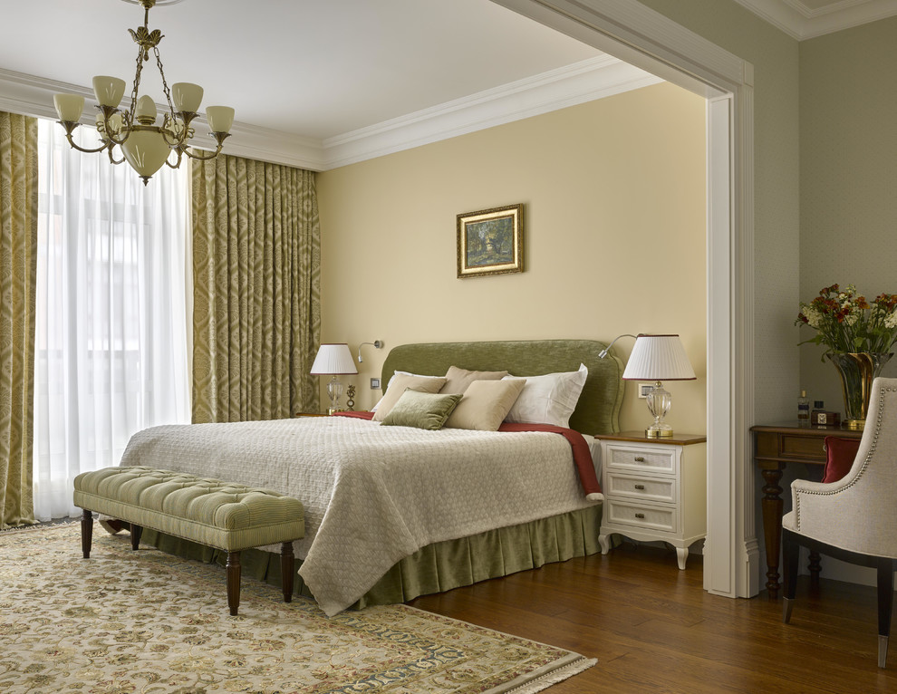 На фото: хозяйская спальня в классическом стиле с желтыми стенами и паркетным полом среднего тона с
