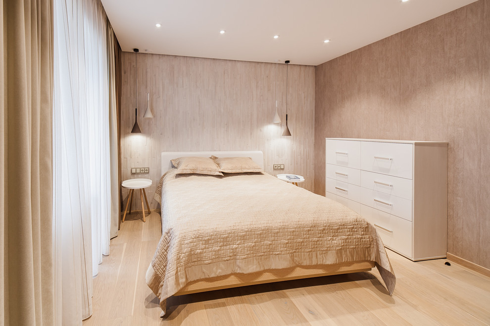 На фото: хозяйская спальня среднего размера в современном стиле с бежевыми стенами, полом из ламината и бежевым полом