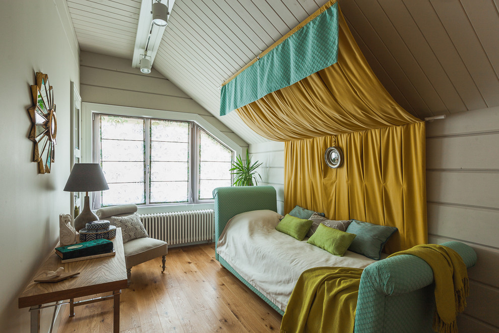Modelo de dormitorio ecléctico con paredes blancas y suelo de madera en tonos medios