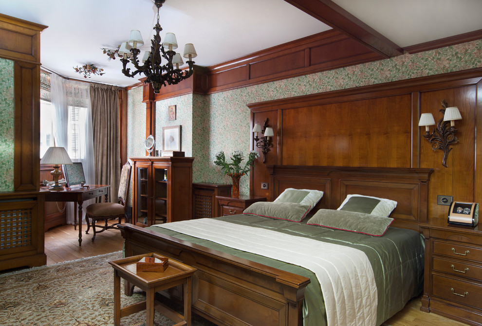 На фото: хозяйская спальня: освещение в викторианском стиле с зелеными стенами, паркетным полом среднего тона и коричневым полом с