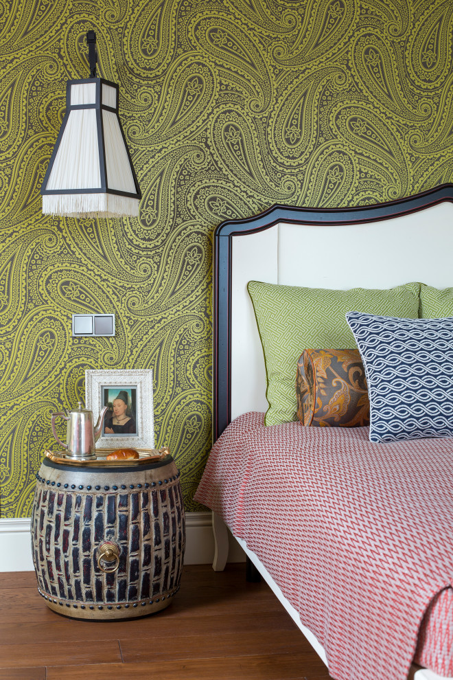 Idée de décoration pour une chambre parentale bohème avec un mur vert, un sol en bois brun et un sol marron.