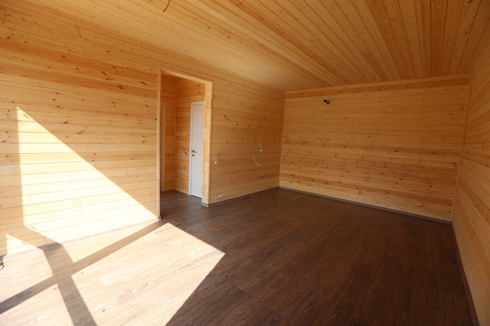 Diseño de habitación de invitados minimalista pequeña con paredes blancas, suelo laminado y suelo marrón