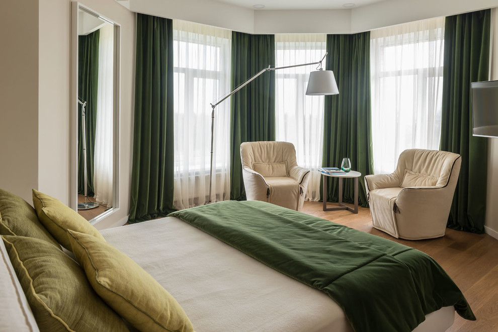 Imagen de dormitorio principal contemporáneo con paredes beige, suelo de madera en tonos medios y suelo marrón