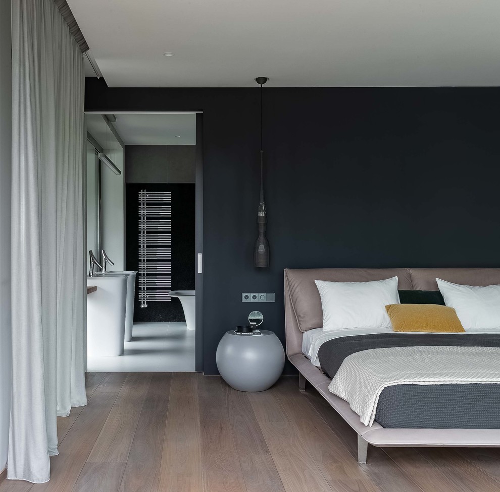 Diseño de dormitorio principal contemporáneo con paredes negras, suelo de madera en tonos medios y suelo marrón