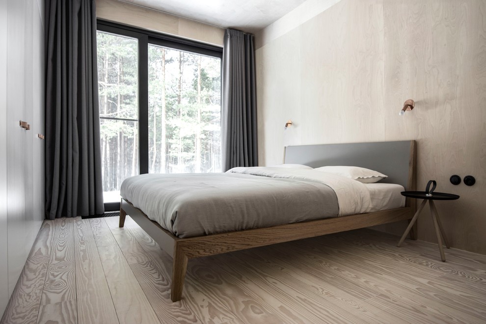 Immagine di una piccola camera matrimoniale con pareti beige, pavimento in legno verniciato e pavimento beige
