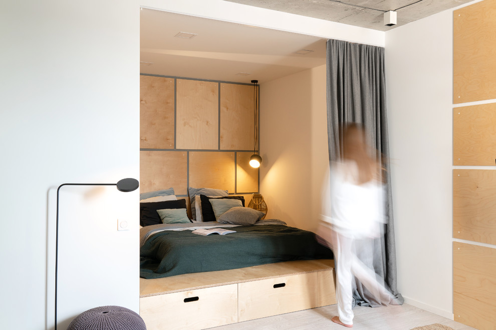 Modelo de dormitorio principal escandinavo con suelo de contrachapado, suelo beige y paredes blancas
