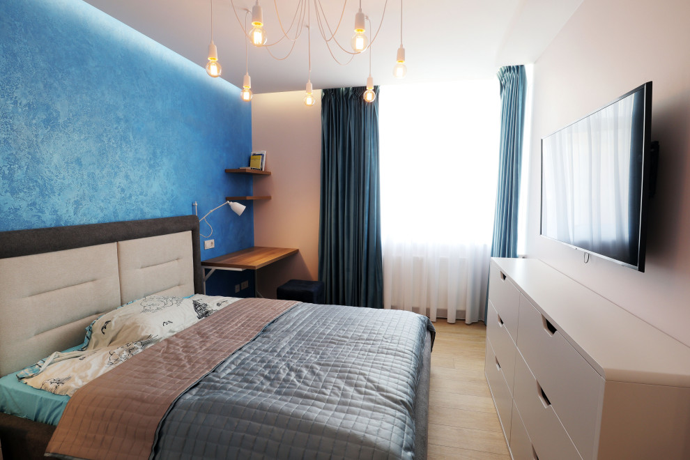 Imagen de dormitorio principal contemporáneo de tamaño medio sin chimenea con paredes multicolor, suelo laminado y suelo marrón