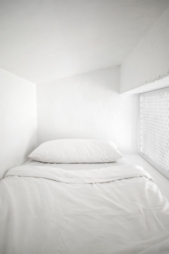 Пример оригинального дизайна: маленькая гостевая спальня (комната для гостей) в стиле лофт с белыми стенами для на участке и в саду