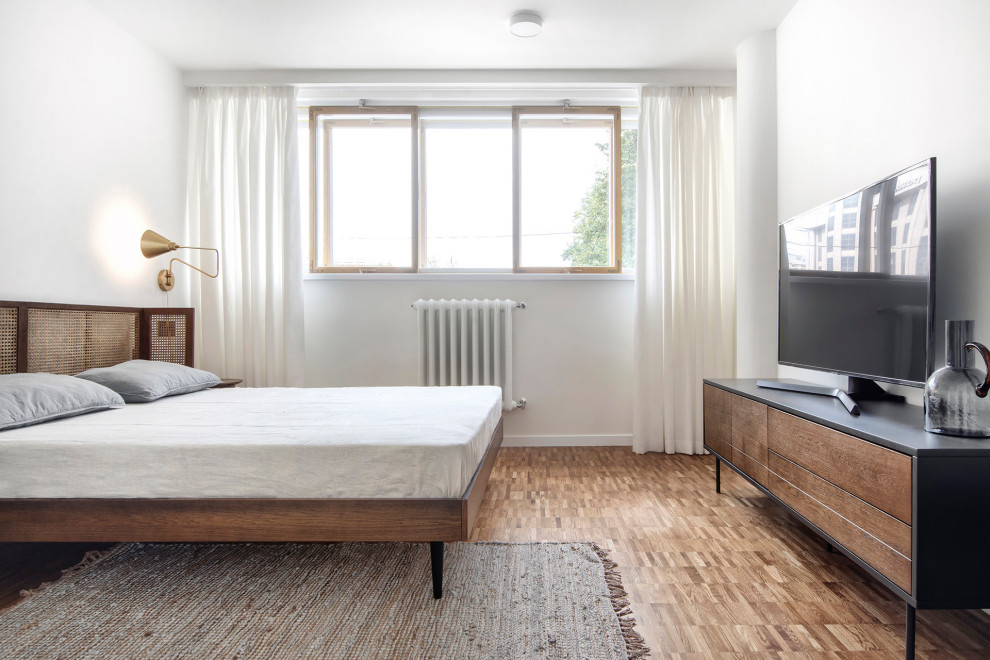 Foto de dormitorio principal moderno pequeño con paredes blancas, suelo de madera en tonos medios y suelo marrón