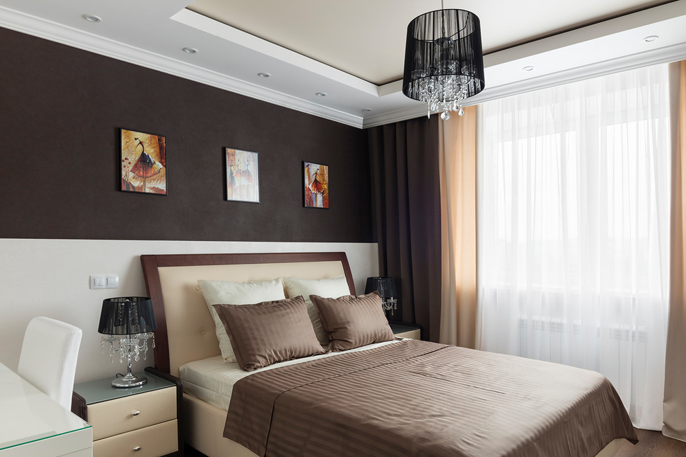 Modelo de dormitorio principal tradicional renovado de tamaño medio con paredes marrones, suelo de madera en tonos medios y suelo marrón