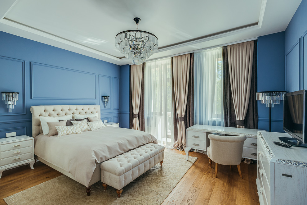 Diseño de dormitorio principal clásico grande con paredes azules, suelo de madera en tonos medios y suelo marrón