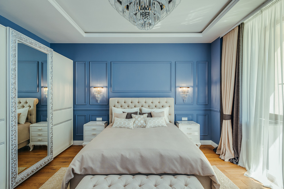 Foto de dormitorio principal tradicional grande con paredes azules, suelo de madera en tonos medios y suelo marrón