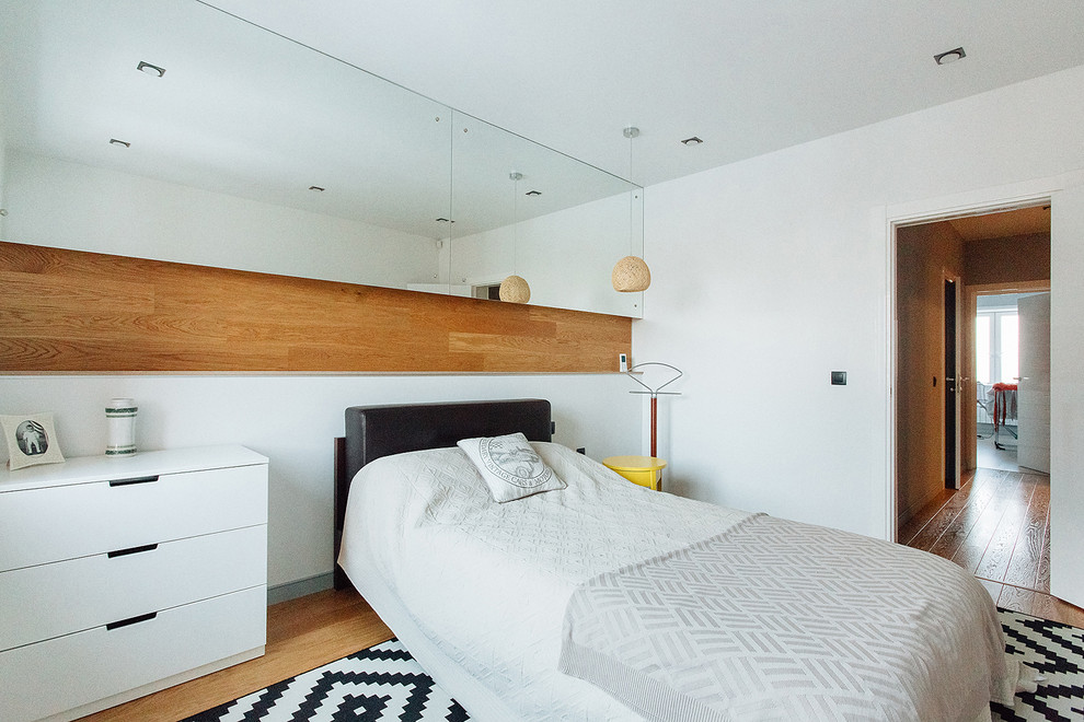Mittelgroßes Nordisches Hauptschlafzimmer mit weißer Wandfarbe und braunem Holzboden in Sonstige