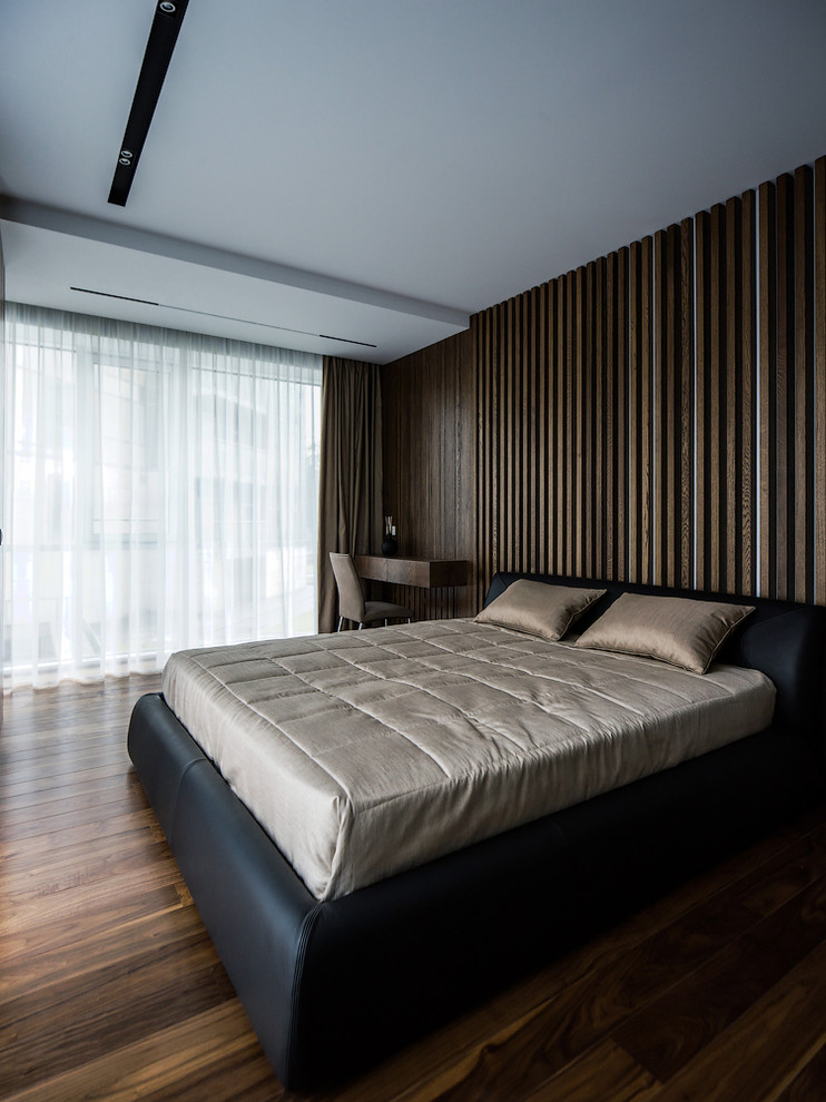 Foto de dormitorio principal contemporáneo grande con paredes marrones, suelo de madera oscura y suelo marrón
