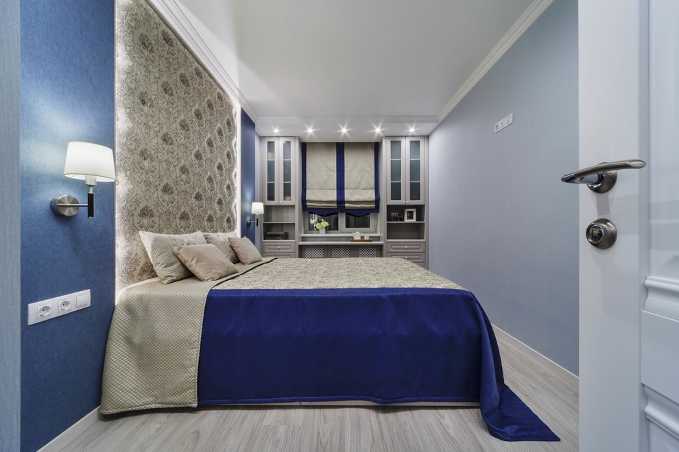 Imagen de dormitorio principal clásico pequeño con paredes azules, suelo laminado y suelo gris