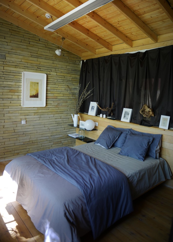 Пример оригинального дизайна: гостевая спальня среднего размера, (комната для гостей) в средиземноморском стиле с коричневыми стенами, деревянным полом и коричневым полом без камина