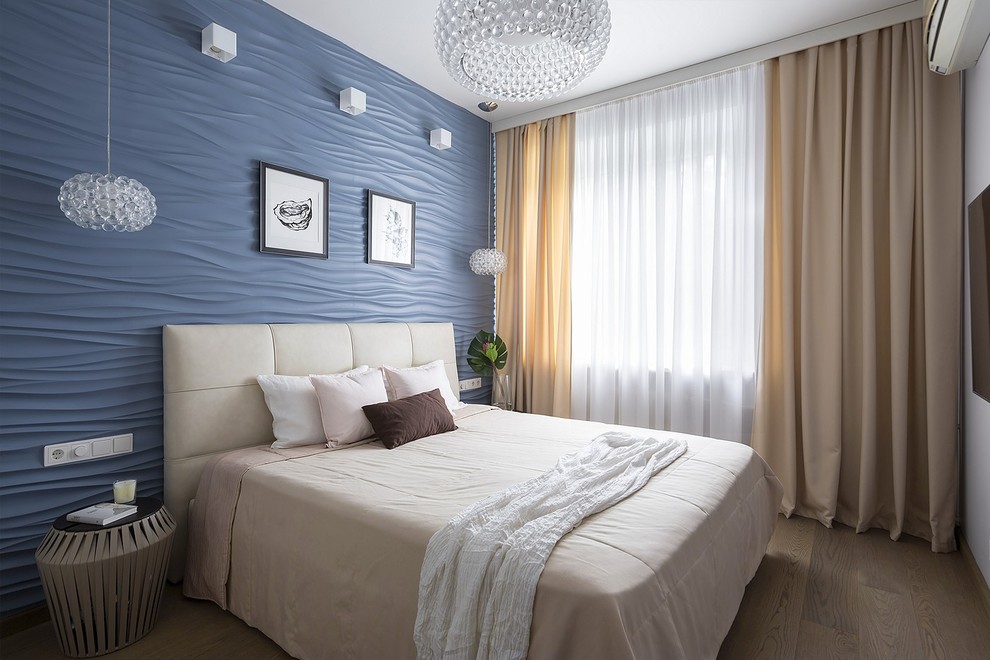 Idee per una camera matrimoniale design con pareti blu, pavimento in legno massello medio e pavimento marrone