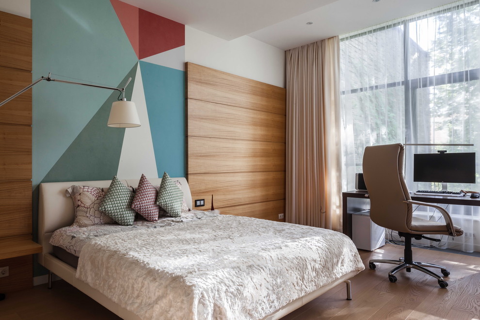 Cette photo montre une chambre parentale tendance de taille moyenne avec un mur blanc, un sol en bois brun et un sol gris.