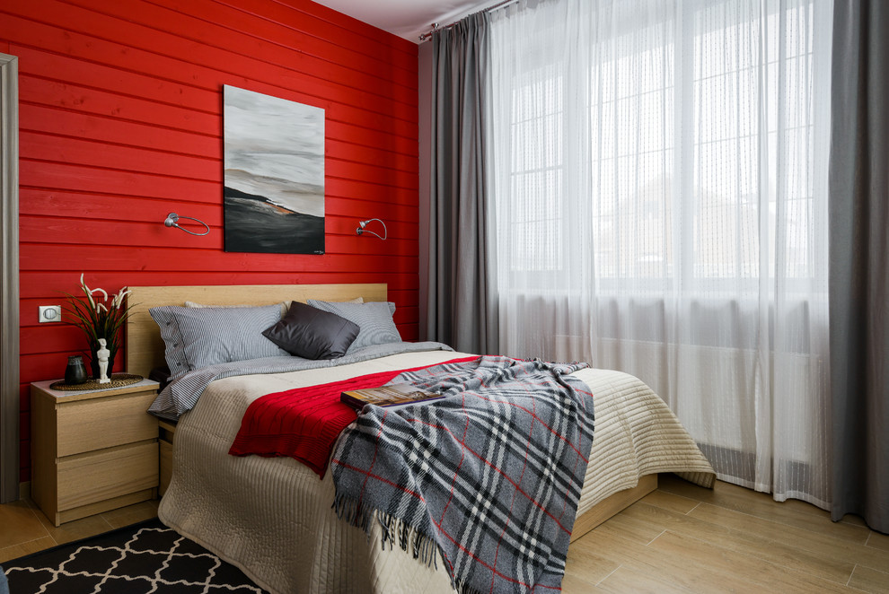Immagine di una camera da letto chic con pareti rosse e parquet chiaro
